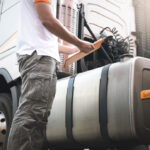 Truck,Driver,Holding,Clipboard,Is,Checking,Semi,Truck,Fuel,Tank.